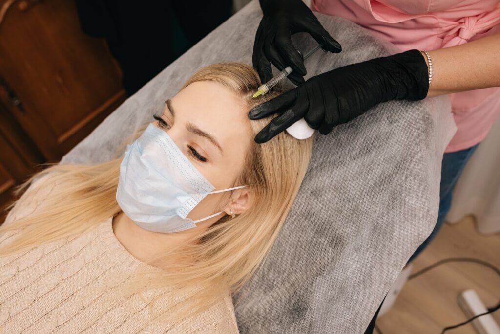 A blonde Woman getting injection on scalp | Hair Regenerative Medicine in Philadelphia, PA | PhillyMedClub