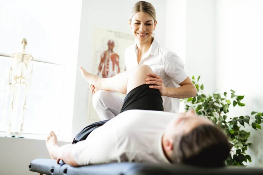 Female doctor checking legs and knees of a sleeping man patient | PRP/PRF Joint Injections in Philadelphia, PA | PhillyMedClub